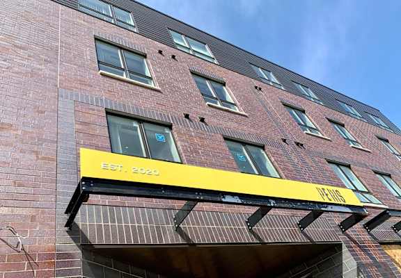 the front of a brick building with a yellow sign