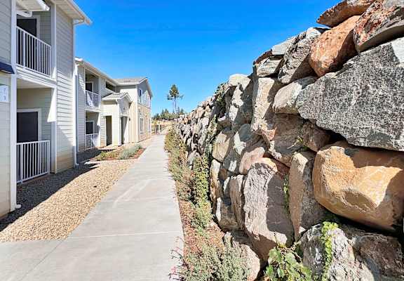 a large rock wall in front of a row of houses