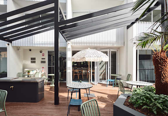 a patio with tables and chairs and a pergola