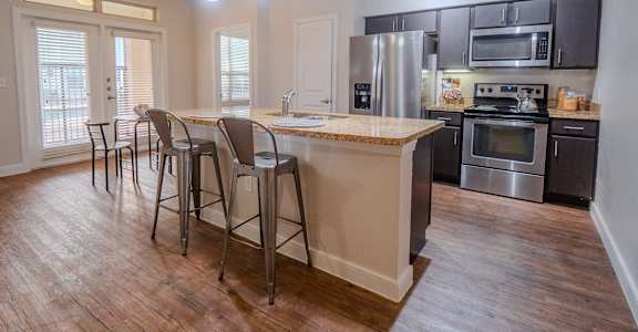A kitchen with a bar area and stools.