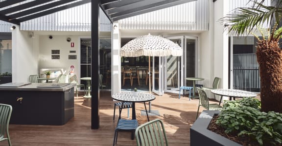 a patio with tables and chairs and a pergola