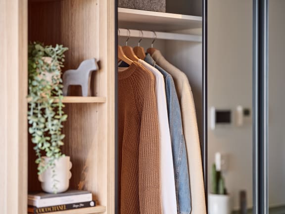 a wardrobe filled with clothes hanging on hangers