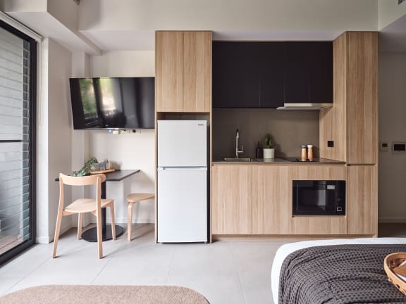 a small kitchen with a white refrigerator and a table and chairs