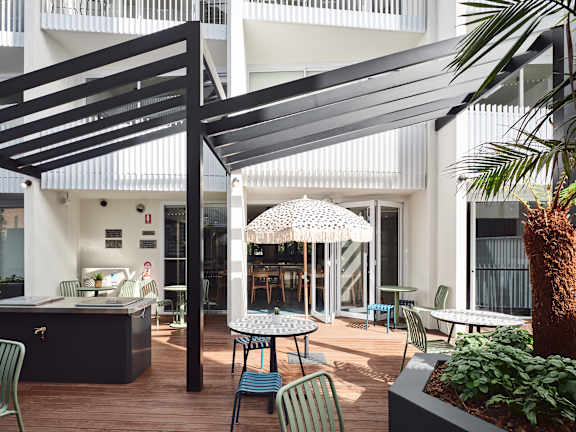 a patio with tables and chairs and a pergola