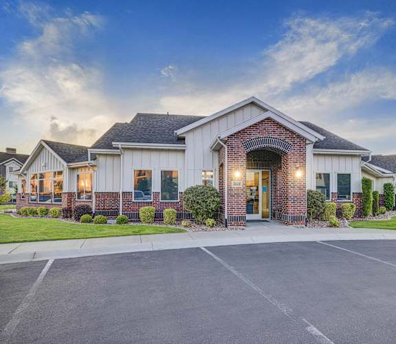 a home with a brick and white facade and a driveway