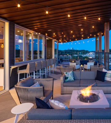 a covered patio with couches and chairs and a fire pit