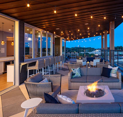 a covered patio with couches and chairs and a fire pit