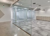 Thumbnail 15 of 19 - A spacious room with a glass partition wall and a tiled floor.
