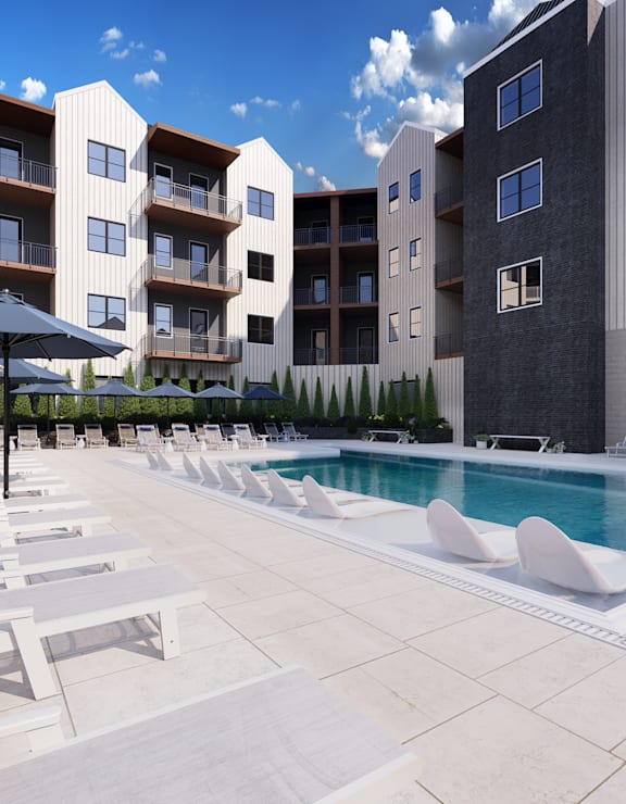 a pool with white lounge chairs in front of an apartment building