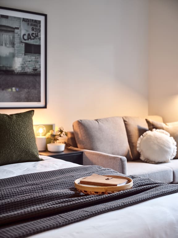 a bed with a black and white blanket and a couch with pillows