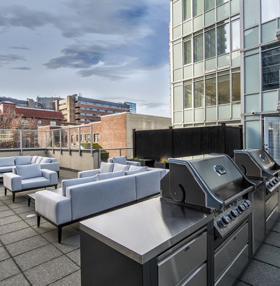 an outdoor patio with a grill and a table with chairs
