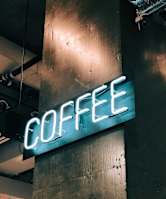 A neon sign that says "COFFEE" is mounted on a wall.