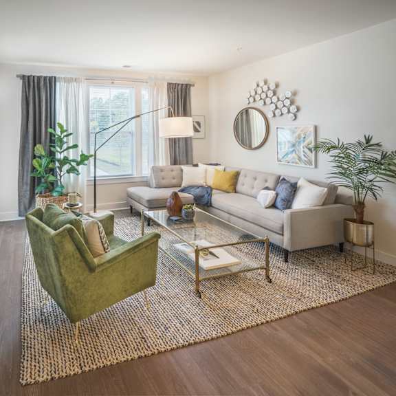 an open concept living room and dining area with a white dining table and rattan chairs at Parc at Princeton Junction Apartments, Princeton, NJ, 08540