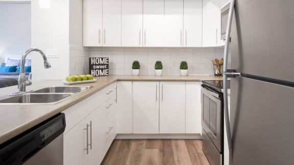 a modern kitchen with white cabinets and stainless steel appliances