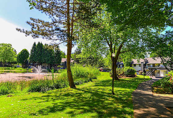 Tree lined walk way with grass at Woodlake Apartments, Kirkland, WA
