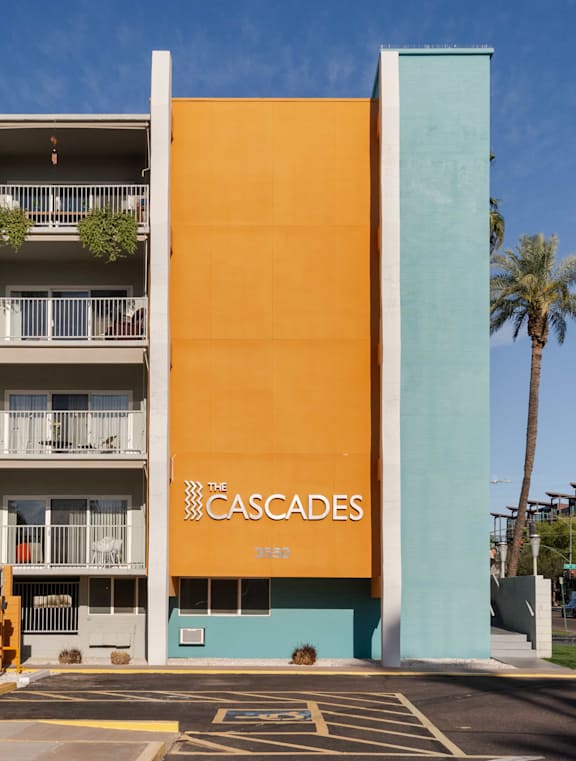 The Cascades apartment building has a yellow and blue exterior.