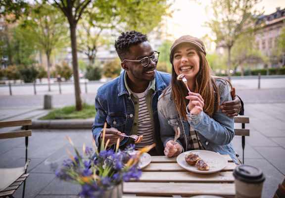 a man and a woman sitting at a table eating food