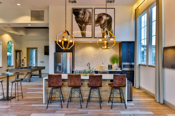 a kitchen with a dining area and a bar with stools at Capriana at Chino Hills, California, 91709