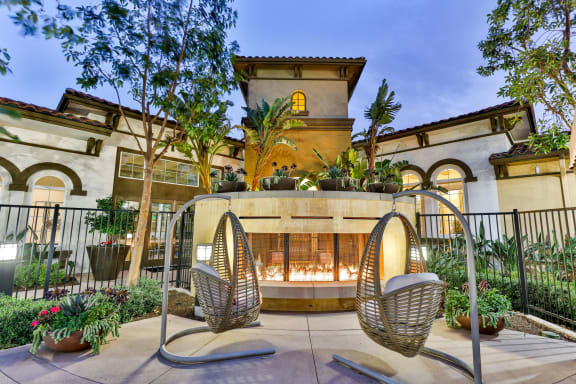 a patio with two chairs and a building in the background at Capriana at Chino Hills, Chino Hills, CA
