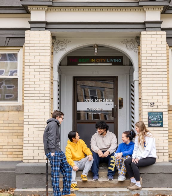 a group of people sitting in front of a building at University Commons in Pittsburgh, PA