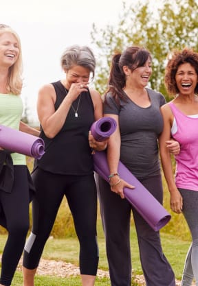 a group of women walking in a park holding yoga mats at Channings Mark, Austin