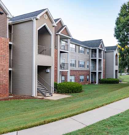 Apartment complex with a green lawn in front.