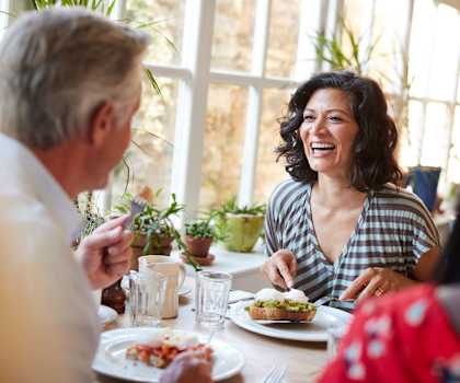 a group of people sitting around a table eating food at Acacia Gardens, Albuquerque, NM, 87111