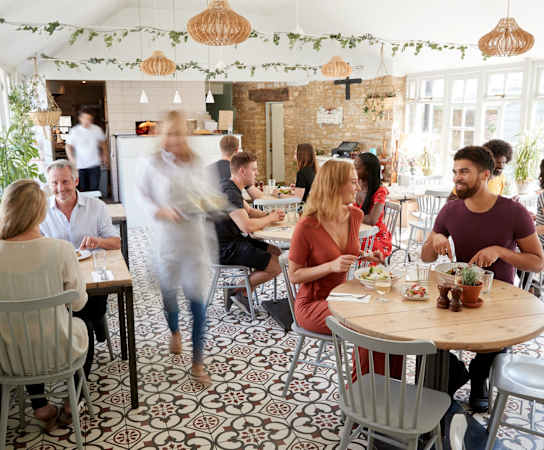 a group of people sitting at tables in a restaurant at Northland at the Arboretum, Austin, Texas