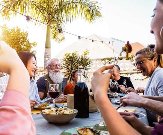 a group of people sitting around a table eating food and drinking wine at Promenade at Reflection Lakes, Florida, 33907