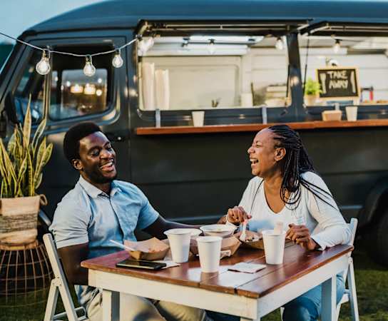 a couple sitting at a table in front of a food truck at Estate at Woodmen Ridge, Colorado, 80923