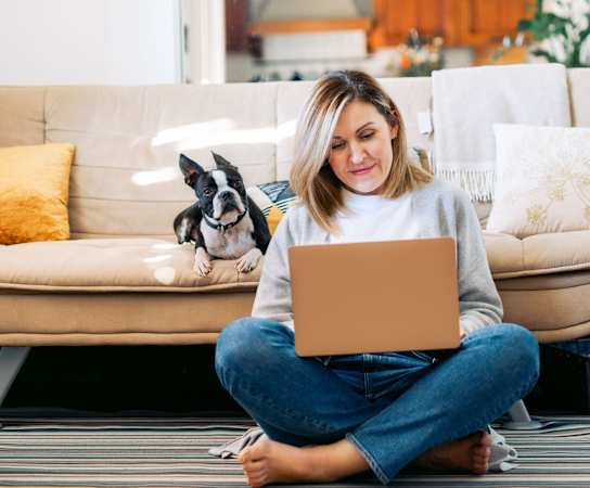 a woman sitting on the floor with her dog and laptop at Stonelake at the Arboretum, Texas, 78759