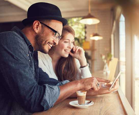 a man and woman sitting at a table in a coffee shop looking at a tablet at Channings Mark, Austin, Texas