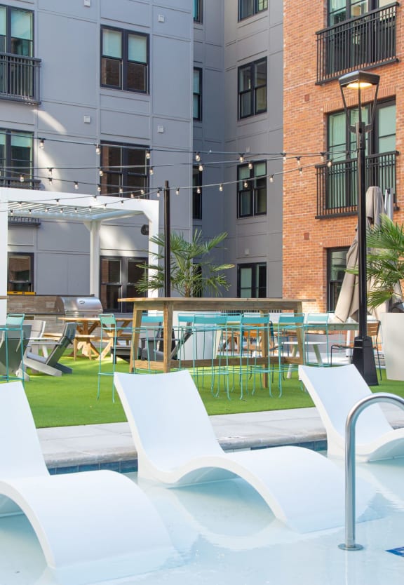 a large pool with white chairs in front of an apartment building at 511 Meeting, Charleston