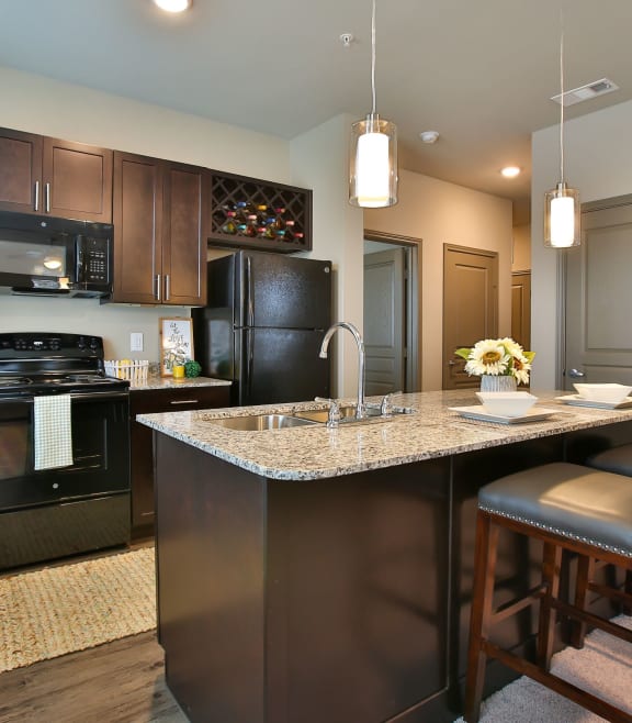 a kitchen with a large island and black appliances at The Legend, Waco