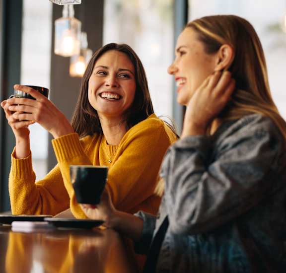 two women sitting at a table drinking coffee at Canyon Creek, Texas, 78759