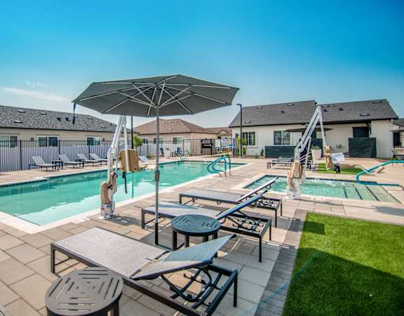 our apartments have a resort style pool with tables and chairs at Parke Place, Prescott Valley, Arizona