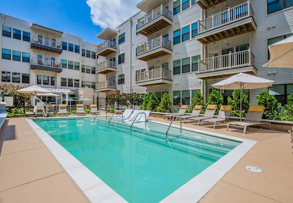 A large swimming pool in front of apartment buildings.