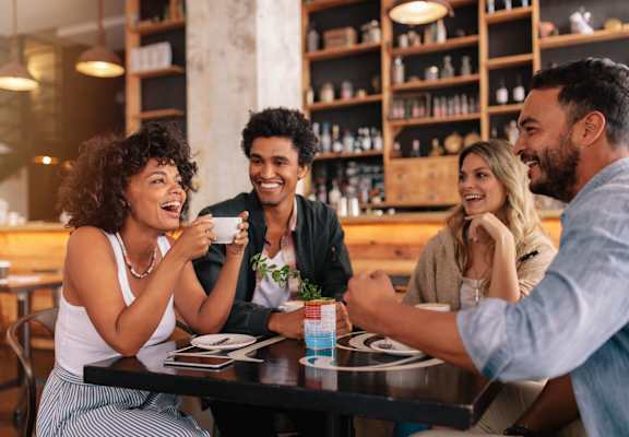 Four people are sitting at a table in a restaurant. at Imperial Hardware Lofts, Riverside, CA, 92501