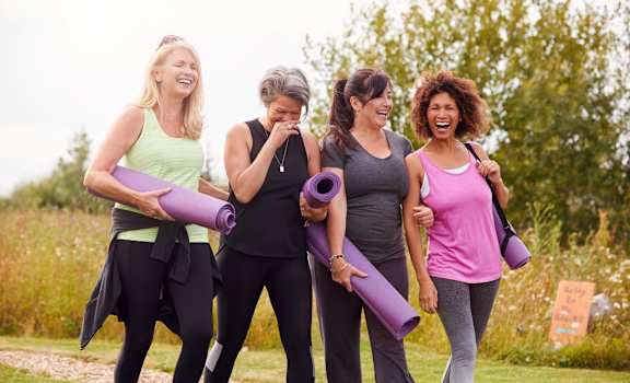 a group of women walking in a park holding yoga mats at Saddleworth Green, Florida, 34474