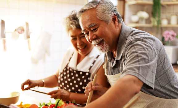 a man and a woman preparing a meal in a kitchen at Barcelona Jupiter, Jupiter, FL