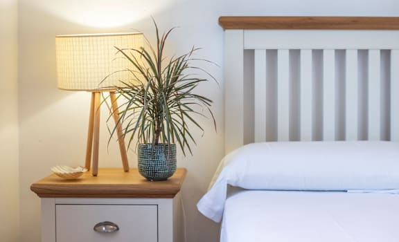 a bedroom with a bed and a nightstand with a lamp  at Residences at Westborough Station, Westborough, MA