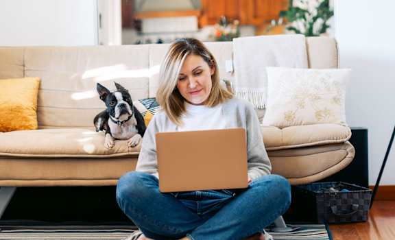 a woman sitting on the floor with her dog and laptop at Maven on Broadway, Minnesota