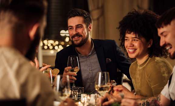 a group of people sitting around a table eating and drinking wine at Maven on Broadway, Rochester, 55904