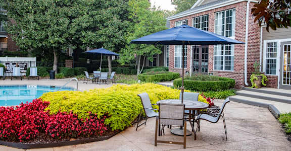 A backyard with a pool and a table and chairs.