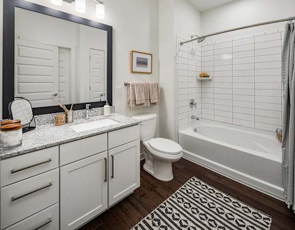 a white bathroom with a shower toilet and sink