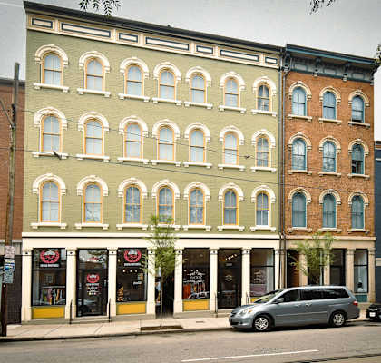 a row of buildings on a city street with cars