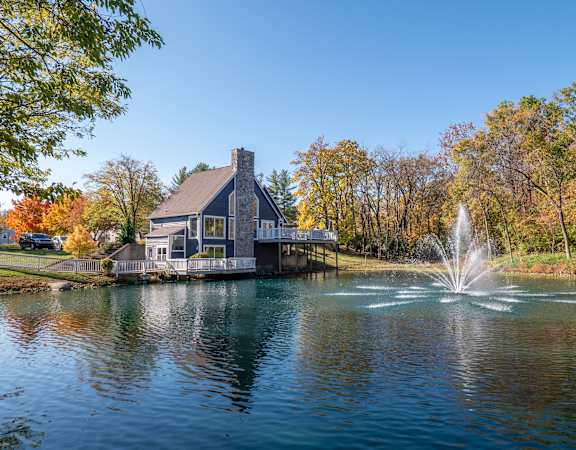 A house with a water fountain in front of it.