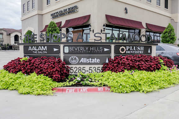 a display of flowers in front of the the sign outside of a building