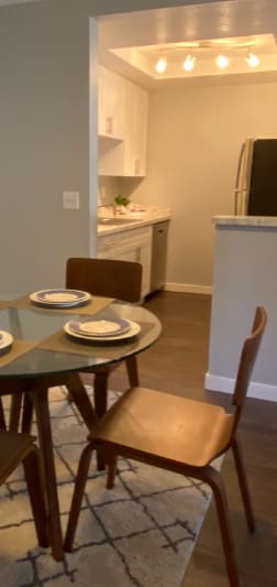 A kitchen with a table and chairs in the foreground.