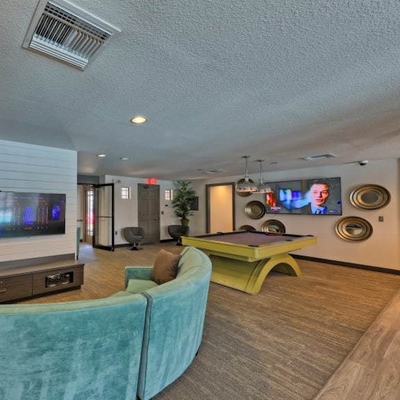 a living room filled with furniture and a flat screen tv at The Monroe Apartment Homes, Florida, 32303